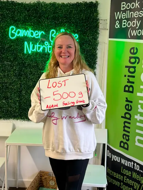 At the Bamber Bridge club, a member holding up the board with her results