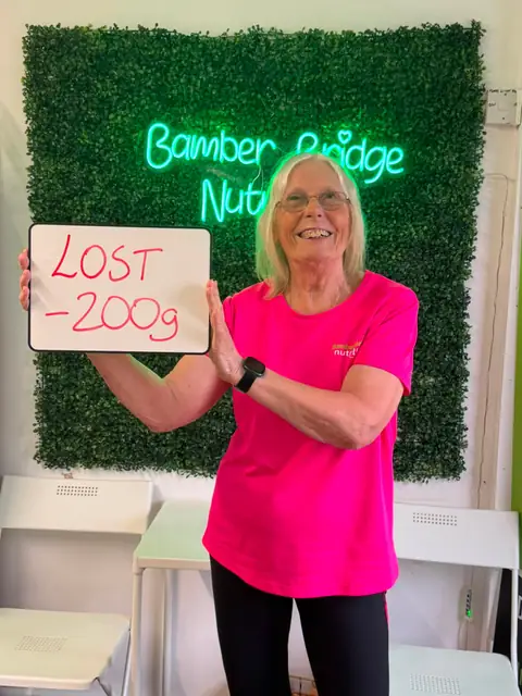 At the Bamber Bridge club, a member holding up the board with her results