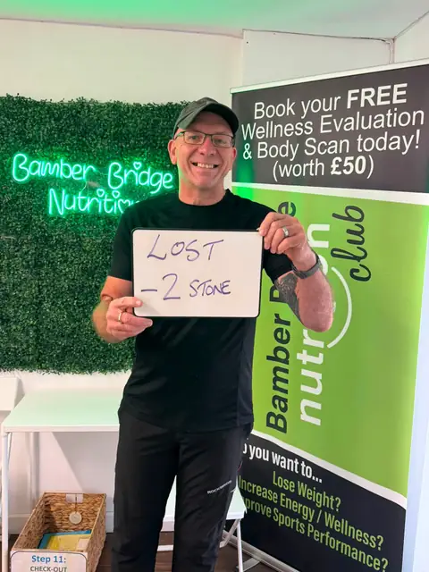 Smiling member at the club showing his results written up on the board