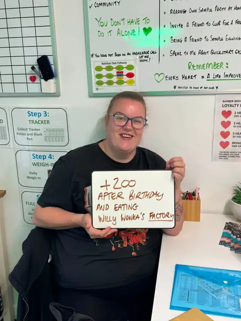 Smiling member at the club showing her results written up on the board