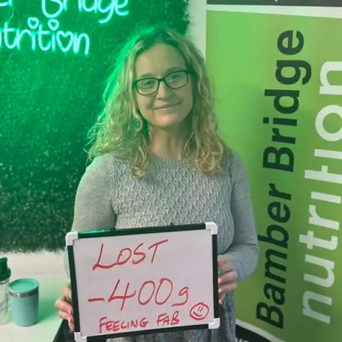 At the Bamber Bridge club, a member holding up the board with her results