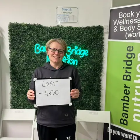 Smiling member at the club showing her results written up on the board