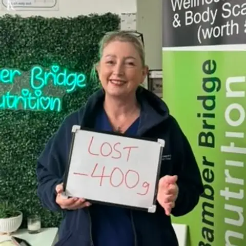 At the Bamber Bridge club, a member holding up the board with her results