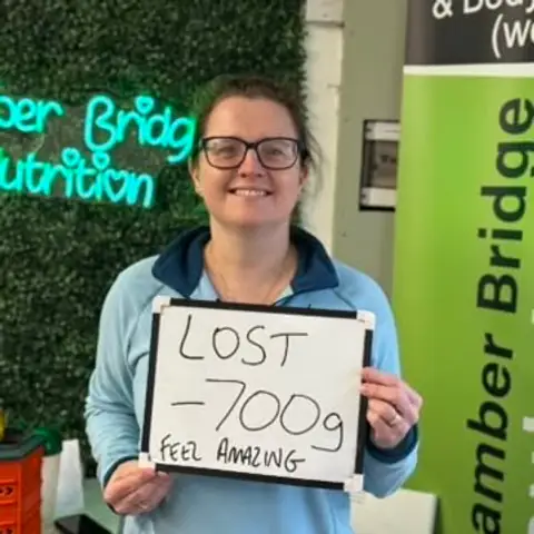 Smiling member at the club showing her results written up on the board