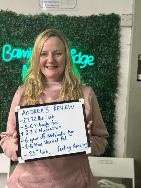 Smiling member at the club showing her results written up on the board
